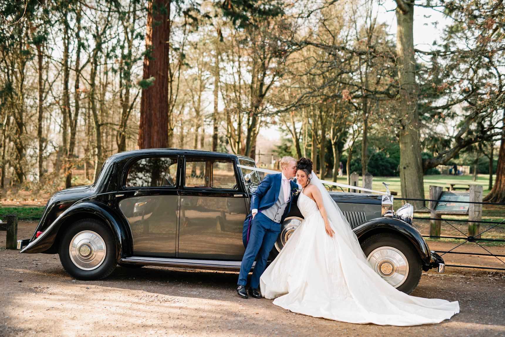 bridal couple by the car 